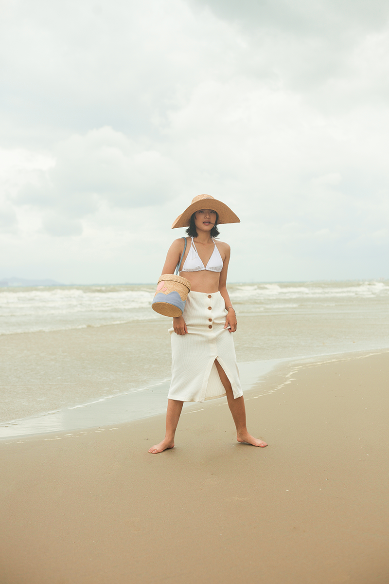 A bucket bag has a fun shape that opens up like a treasure chest from childhood. It includes a heart shape on the top of the lid and a plush handle, among other charming elements that are lovingly handcrafted.