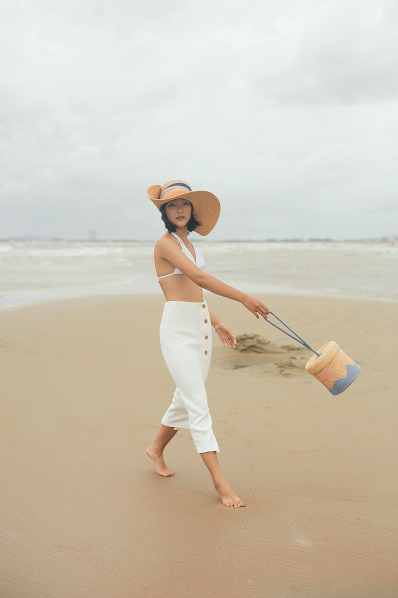 A bucket bag has a fun shape that opens up like a treasure chest from childhood. It includes a heart shape on the top of the lid and a plush handle, among other charming elements that are lovingly handcrafted.