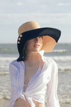 Charger l&#39;image dans la visionneuse de galerie, Romy wide brim hat from natural raffia and black cotton canvas At the beach